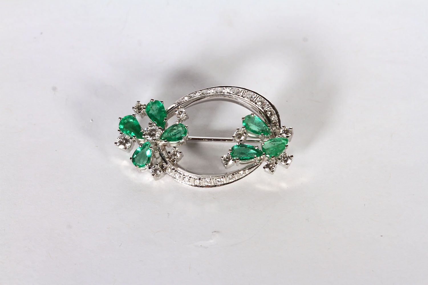 14CT WHITE GOLD EMERALD AND DIAMOND BROOCH ,PRONG SET AND STYLED AS TWO FLOWERS WITH EMERALD
