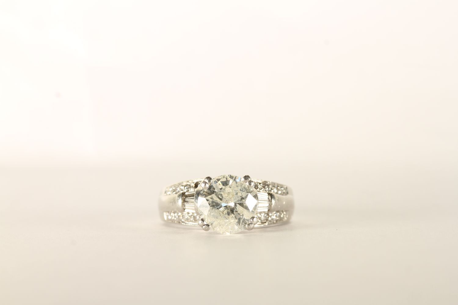 Diamond Ring, centre set with 1 round brilliant cut diamond, claw set, shoulders set with baguette