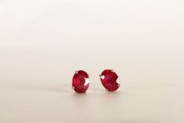 Pair of Ruby Stud Earrings, each set with an oval cut treated ruby, 4 claw set, stamped sterling