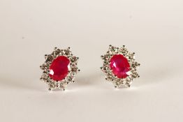 Pair of Ruby and Diamond Stud Earrings, each set with an oval cut ruby, total approximate ruby