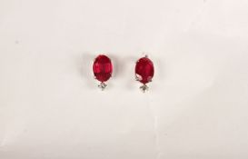 Pair of Ruby and Diamond Stud Earrings, each set with an oval cut ruby, 4 claw set, total