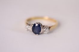 18ct Sapphire and Diamond three stone ring, central oval cut blue sapphire, a brilliant cut