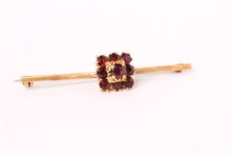 Garnet cluster bar brooch, cluster of 9 round cut garnets, set on a yellow gold bar, stamped 18ct,