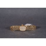 LADIES GARRARD GOLD COCKTAIL WATCH, rounded silver dial with gold hour markers and hands, 16mm
