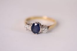 18ct Sapphire and Diamond three stone ring, central oval cut blue sapphire, a brilliant cut