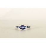 Sapphire and diamond ring, mounted in white metal stamped 18K, central oval sapphire claw set,
