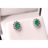 Pair of boxed emerald and diamond cluster studs, oval-cut emeralds total approximately 1.90ct, round