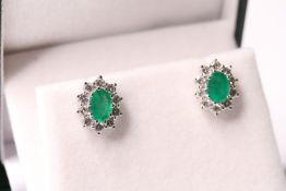 Pair of boxed emerald and diamond cluster studs, oval-cut emeralds total approximately 1.90ct, round