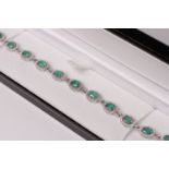 18ct white gold emerald and diamond line bracelet, oval-cut emeralds total approximately 7.12ct,