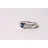 18ct white gold sapphire and channel-set diamond ring, central emerald-cut sapphire