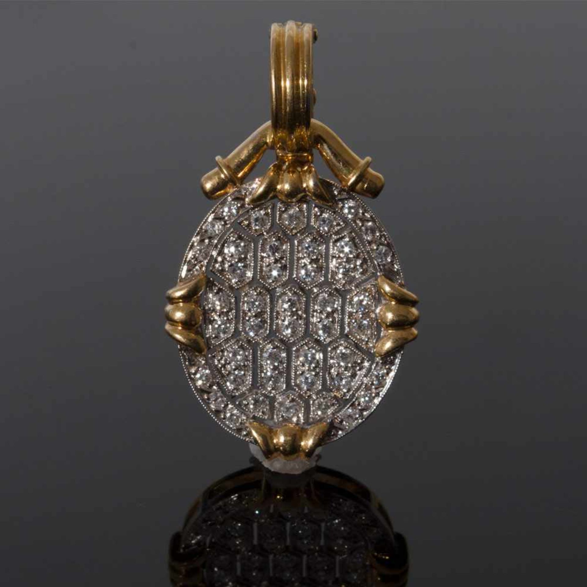 Colgante ovalado en oro bicolor calado con diamantes.