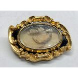 Large victorian gold and enamel mourning brooch with central glass panel