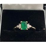 18ct gold Emerald and diamond ring central emerald measures approx 7mm by 4.9mm set with 3 small dia