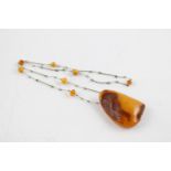 Length measures approx. 72cm and the pendant is approx. 6.7cm by 4.8cm Confirmed as amber using