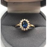 18ct gold sapphire and diamond ring cental sapphire measures approx 7mm by 5mm with small diamonds