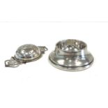 Silver tea strainer on stand