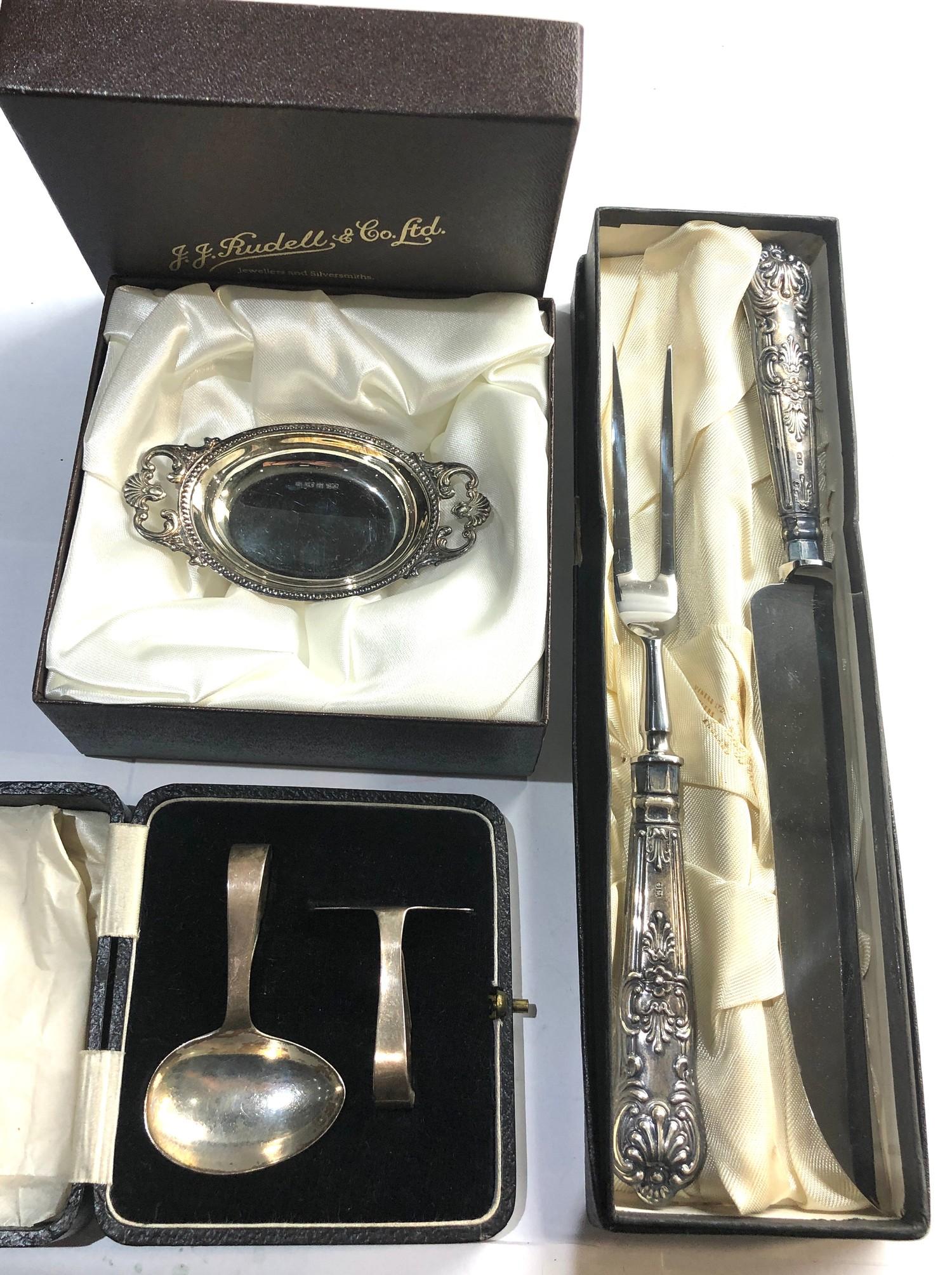 3 Boxed silver items includes baby feeder sweet dish and silver handled carving knife and fork