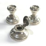 Pair of squat silver candle sticks and a silver ink well with glass liner