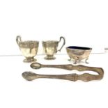 Selection of silver items includes Georgian silver sugar tongues silver salt and 2 silver cups
