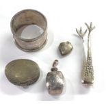 Selection of silver items includes pillbox napkin ring sugar tongues etc uncleaned condition