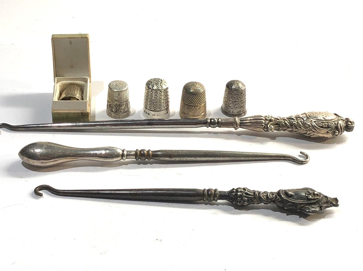 Selection of silver items includes thimbles and button hooks