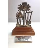 An Iraqi neillo and silver palm tree on a wooden base with another similar large cigarette case