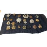 collection of military cap badges on old cloth