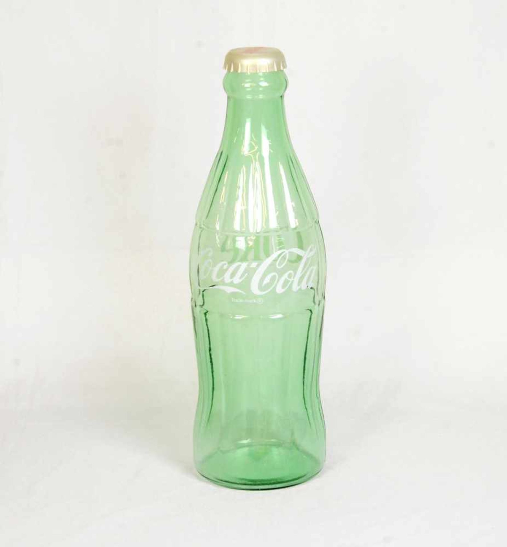 Huge glass Coca-Cola bottleHuge Coca-Cola bottle made out of light green glass with a plastic cap.