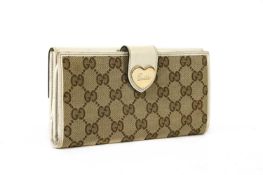 A Gucci beige monogrammed canvas and cream leather heart bi-fold wallet,