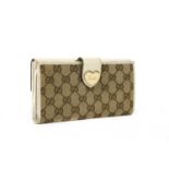 A Gucci beige monogrammed canvas and cream leather heart bi-fold wallet,