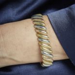 POIRAY ANNEES 1980 - BRACELET RUBAN TROIS ORS - Le bracelet articulé simule une [...]