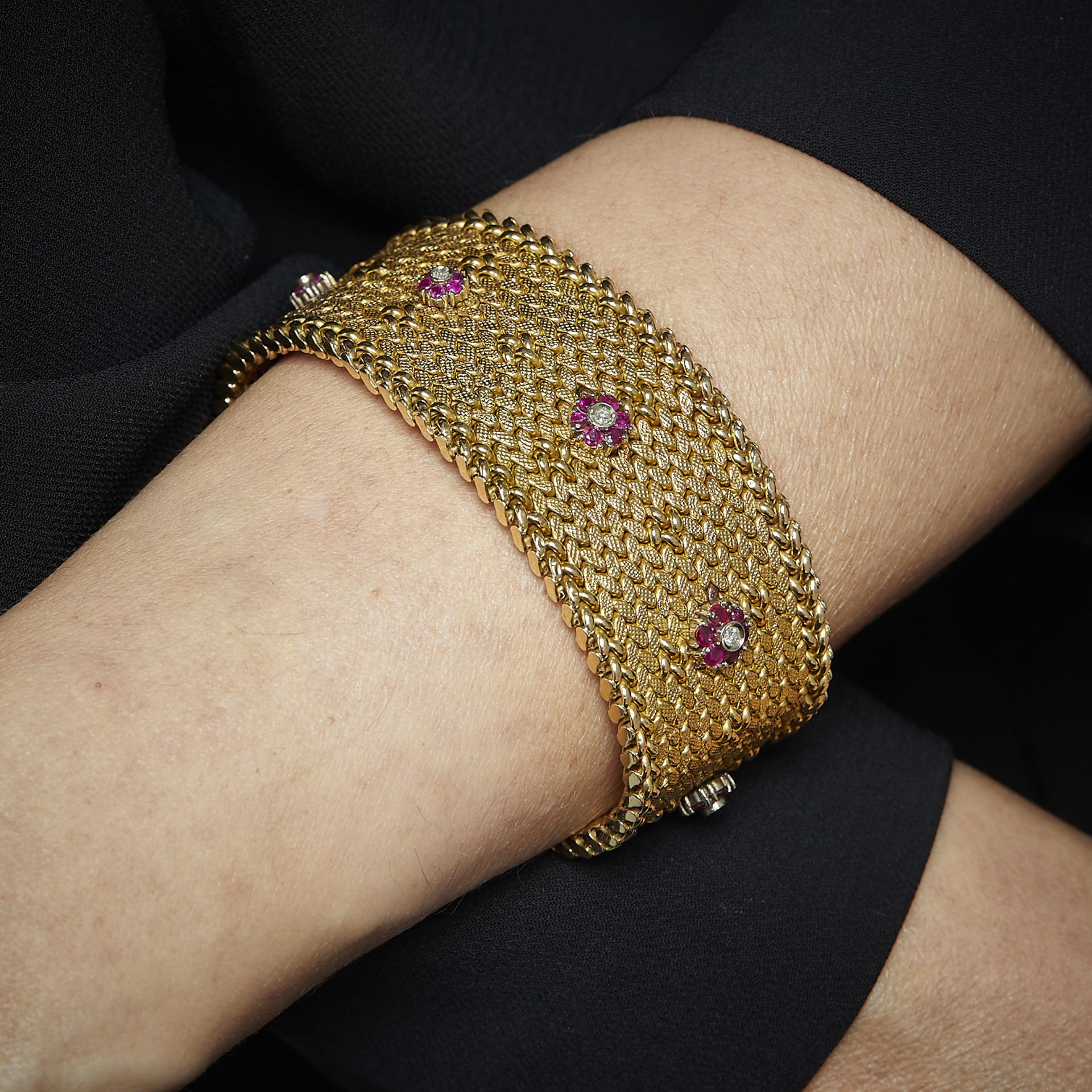 ANNEES 1950 - LARGE BRACELET RUBAN RUBIS DIAMANTS - Il est en or jaune tressé, [...]