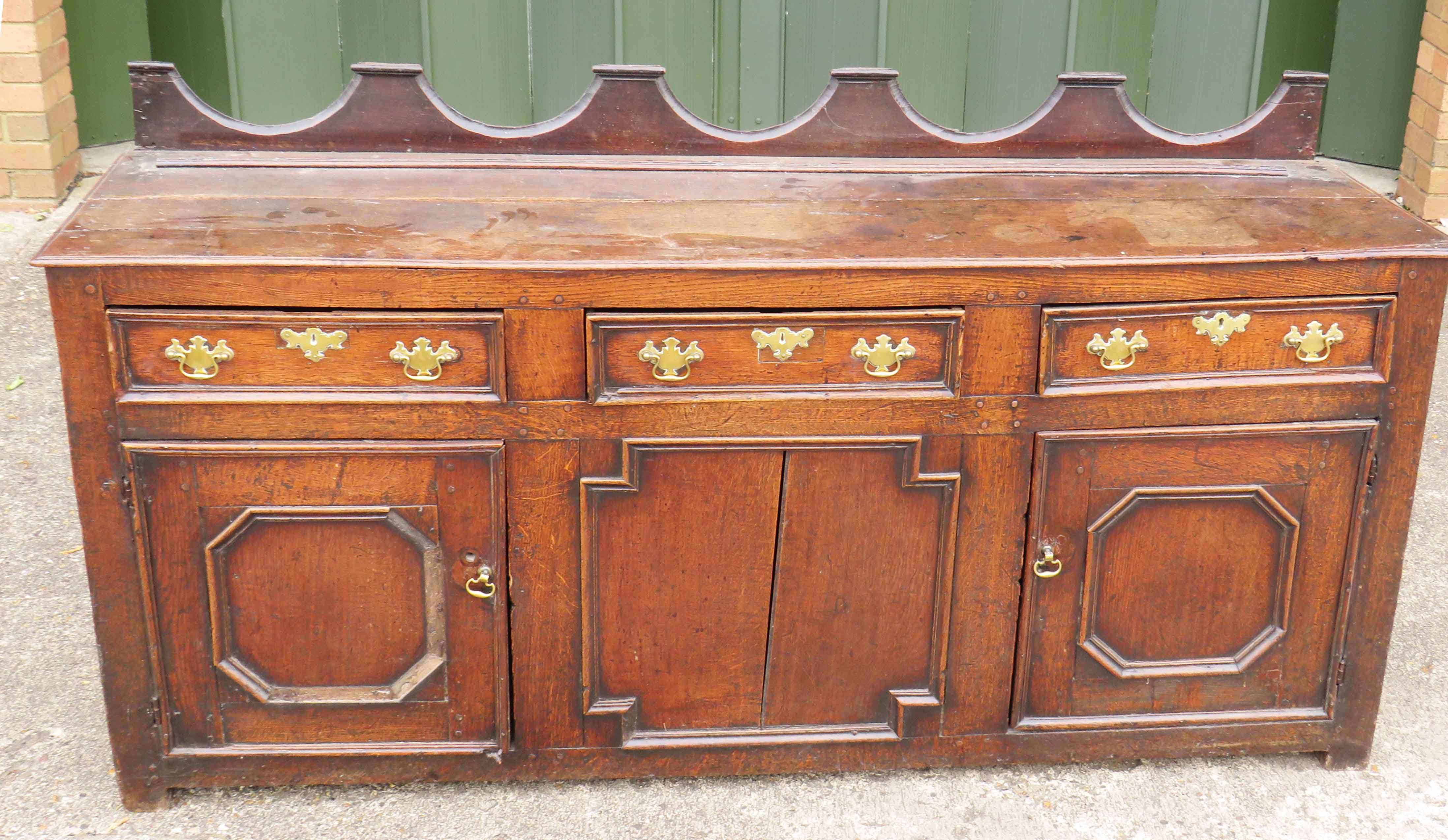 Early 18th Century Queen Anne Period Oak Dresser Base having shaped upstand to top over three frieze