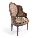 A late 19th century French Louis XVI style walnut carved child's bergère chair