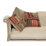 A pair of new tapestry style cushions of library books on shelves with a grey chenille cushion