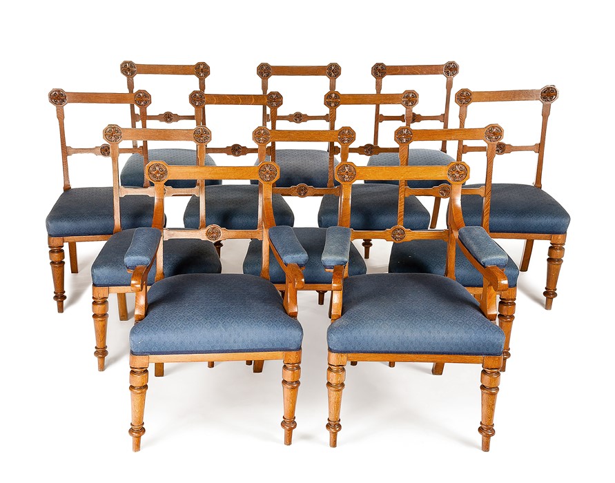 A set of twelve Victorian Gothic Revival carved oak dining chairs incl. a pair of open armchairs