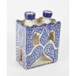 A terracotta Moroccan candle holder, painted in blue and white.