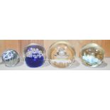 Four glass paperweights including one Caithness example.