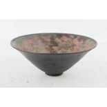 A Chinese bowl, with a black ground, the interior with slip decoration.