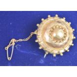 A Victorian yellow metal mourning brooch with safety chain.