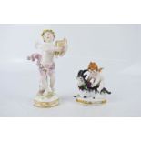 Two Dresden style porcelain figurines; a cherub with goat 7cm high and one with a lyre 13cm high.