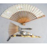 A Haitian comb, inlaid with gilded wire, a Bavarian porcelain pipe, a wooden fan with silk painted