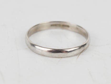 A platinum ladies wedding band, marked 725, 2.5g.