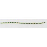 An 18ct emerald and diamond line style bracelet with trap cut emeralds, each with two diamonds