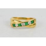 An 18ct gold and emerald cross over half eternity ring, size O/P, set with four square cut emeralds,