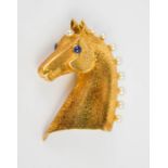 An 18ct gold Cartier brooch in the form of a horses head, finely engraved with detail, inset with