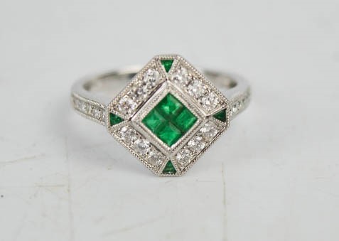 An 18ct white gold, emerald and diamond Art Deco style ring, with four brilliant cut emeralds,