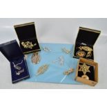 A group of brooches, to include three gold coloured examples, a necklace and earrings set in the