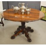 A 19th century rosewood breakfast table with tilt top, and finely carved base, raised on paw feet.