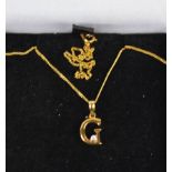 A 9ct gold necklace marked 375, with pendant in the form of initial G, set with diamond.